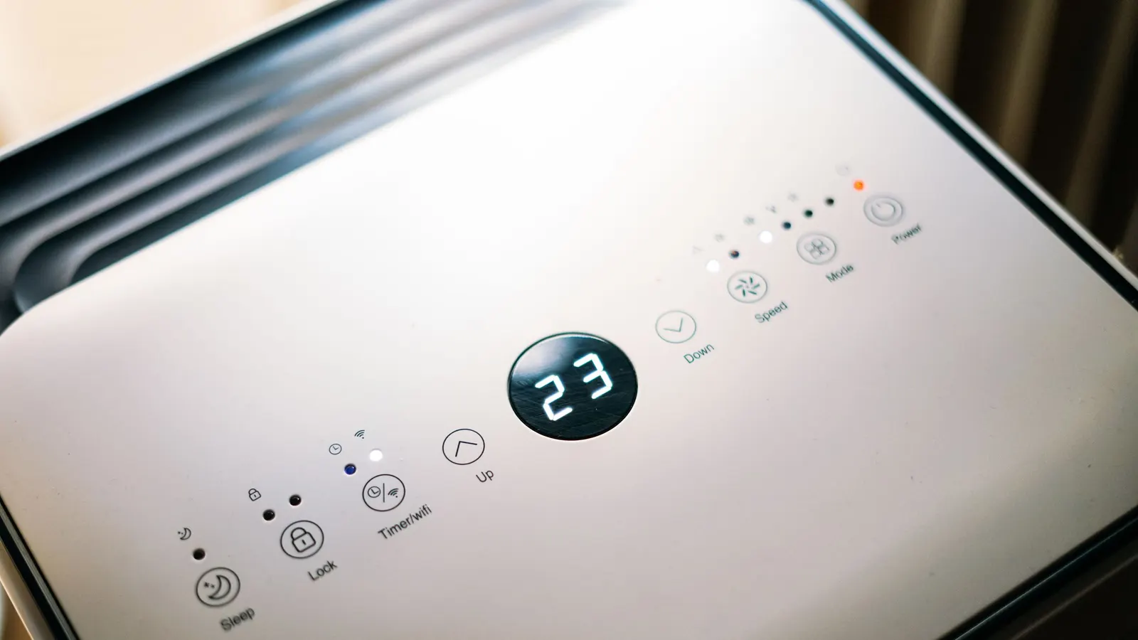 An air conditioner control panel with a digital display and mode buttons