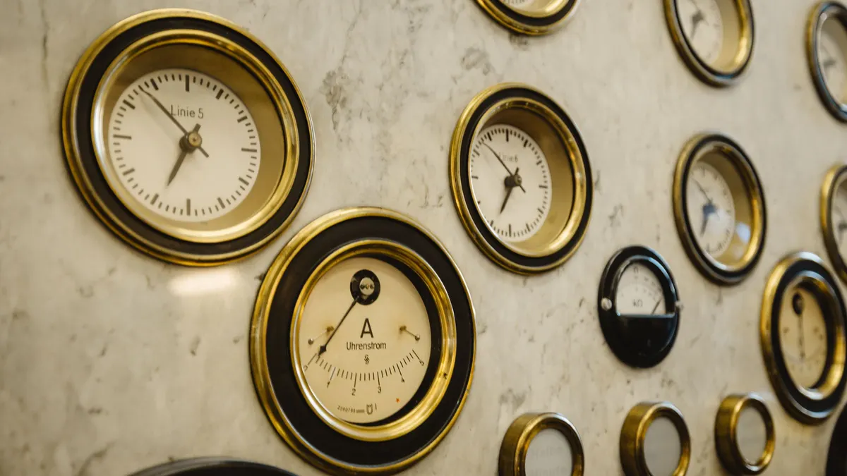 A collection of antique dial gauges mounted on a wall