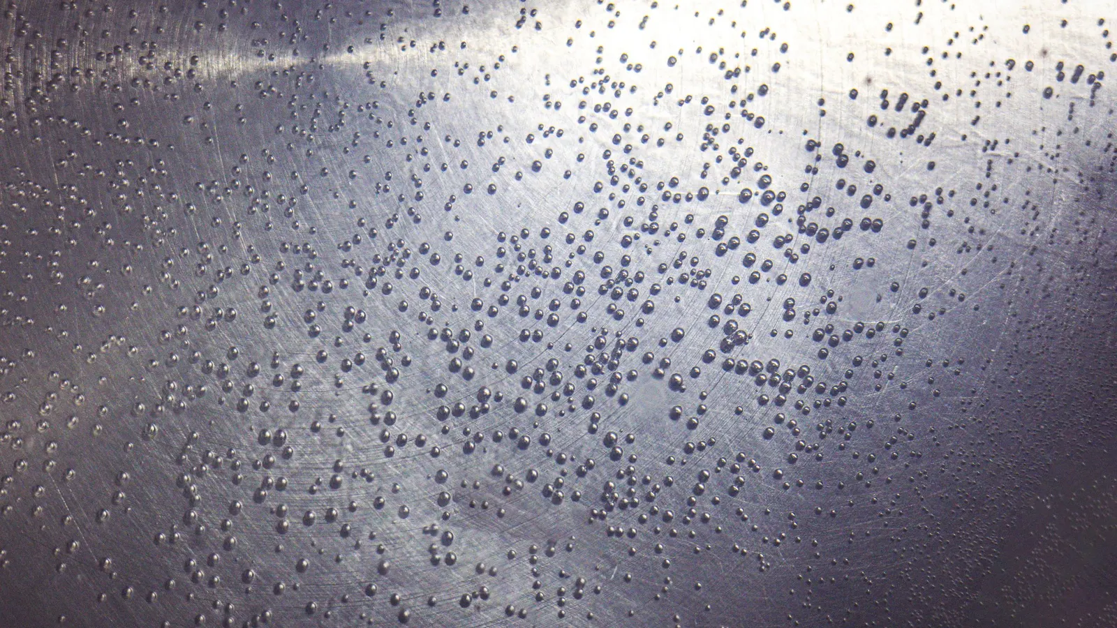 Small water droplets covering a textured metal surface