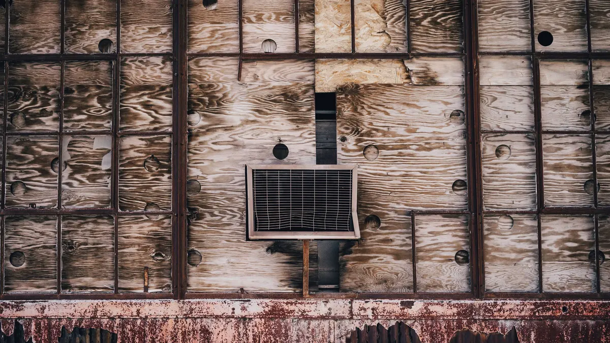 A weathered timber wall with a fitting set into its centre