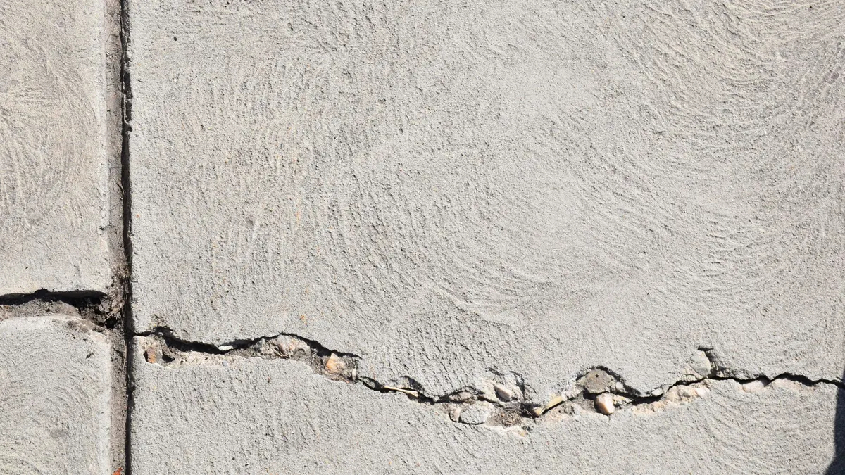A close-up of a crack running through a pale concrete surface