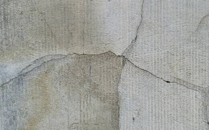 A crack running horizontally across a grey concrete wall