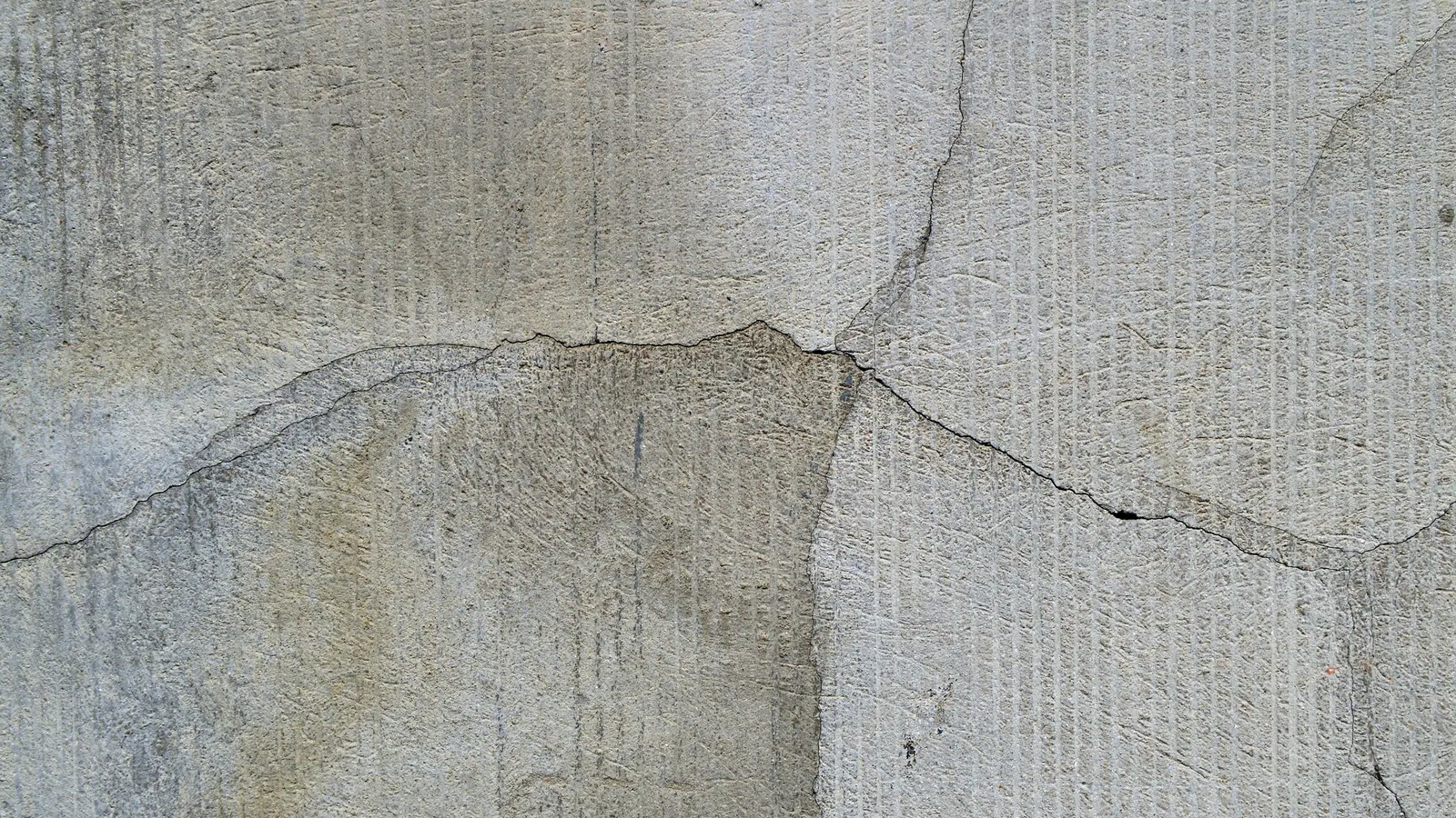 A crack running horizontally across a grey concrete wall