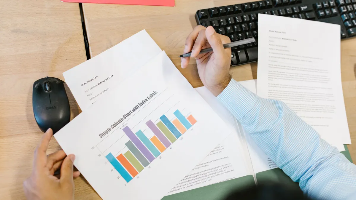 A person reading a printed report containing a bar chart