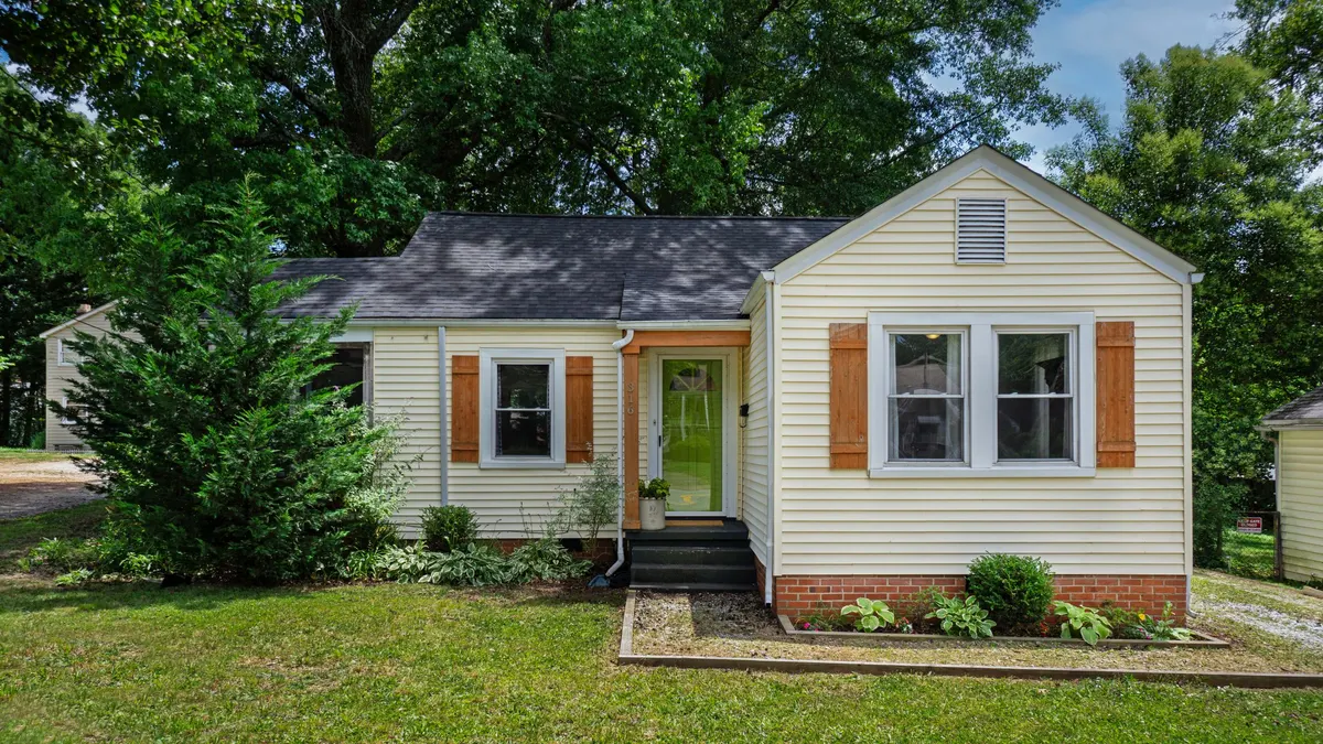 A small single-storey house with a lawn and front steps