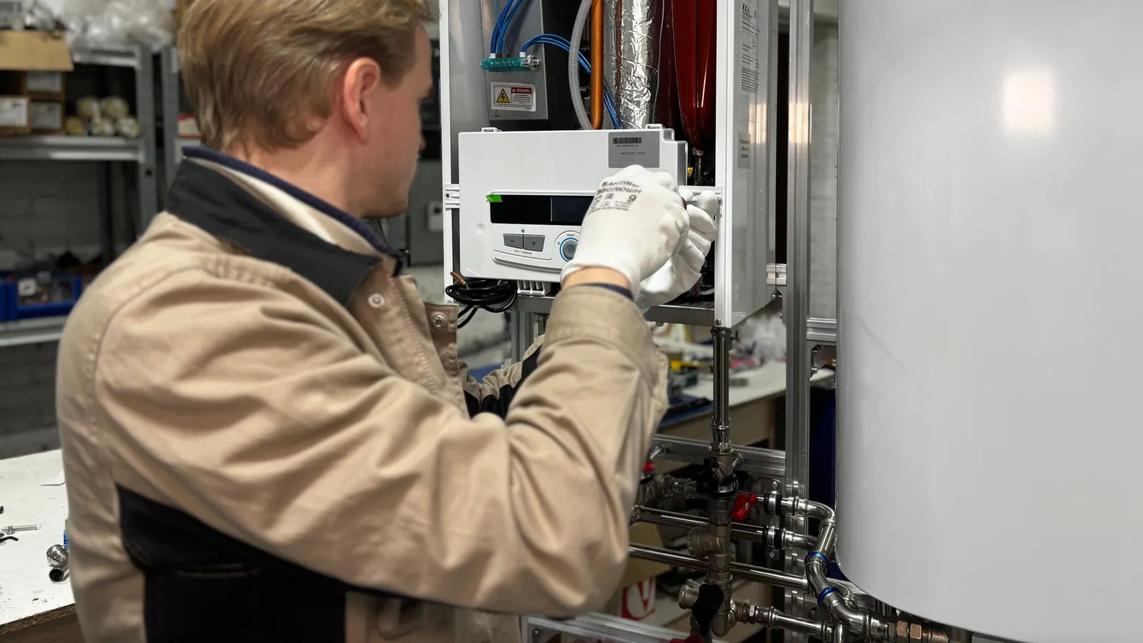 A technician servicing mechanical equipment in a utility room